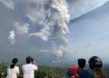 Personas tomando fotos de la nube de cenizas lanzada por el volcán Taal, uno de los más activos de Filipinas, el 12 de enero de 2020.