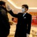 Un guardia de seguridad comprueba la temperatura de un hombre en un centro comercial en Shangái (China), el 8 de febrero de 2020. (AFP).